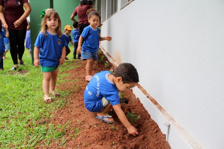 Crianças da Creche Mundo Mágico plantam flores em frente a Gerência de Educação