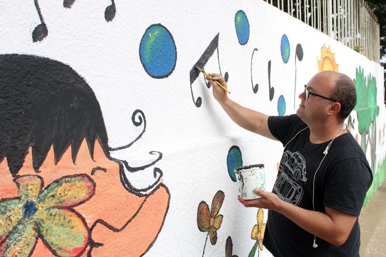 Professor de Naviraí realiza pintura artística em muro de escola usando artes visuais baseadas na Educação Infantil